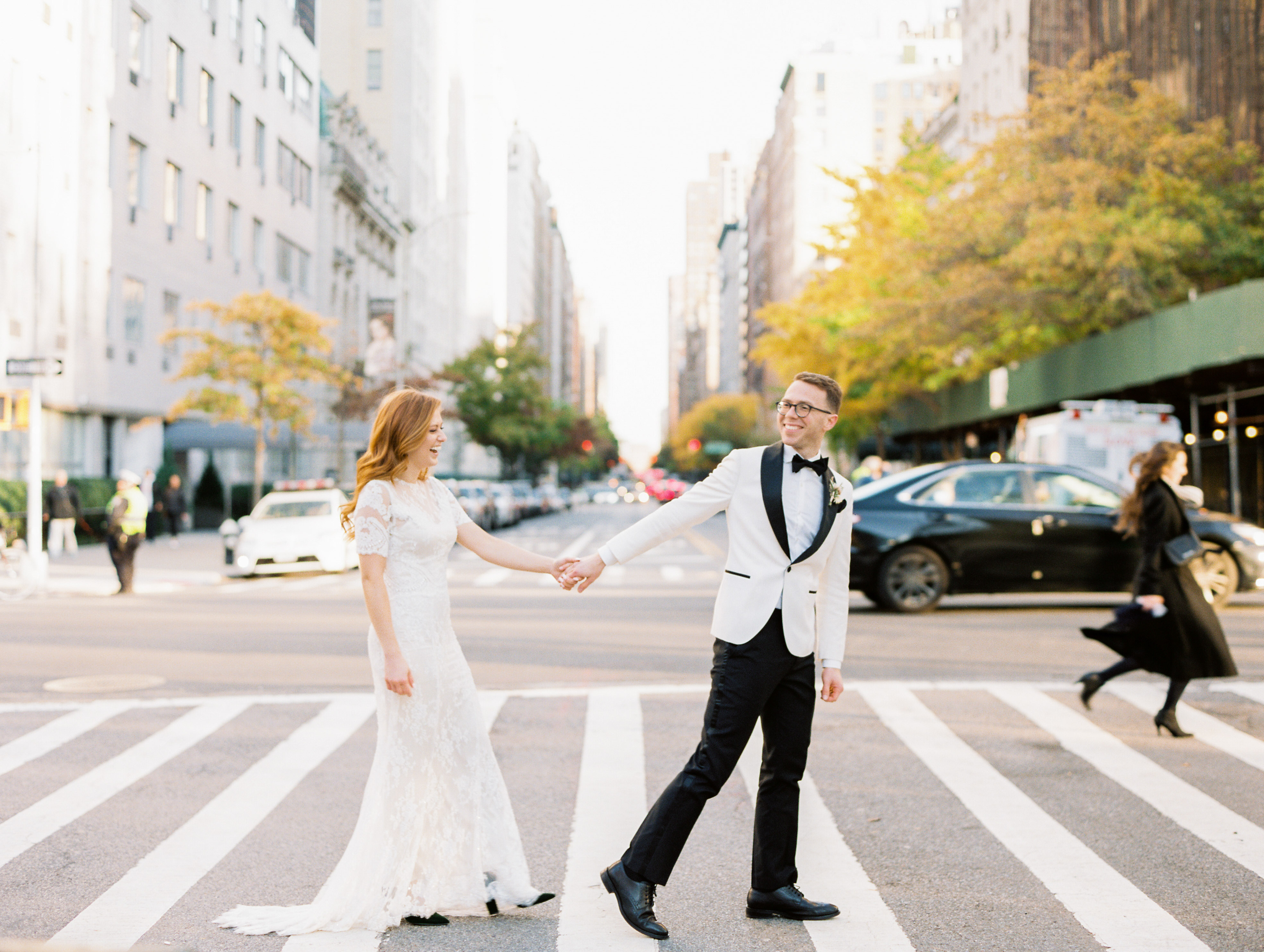 bride and groom walking across bustling street