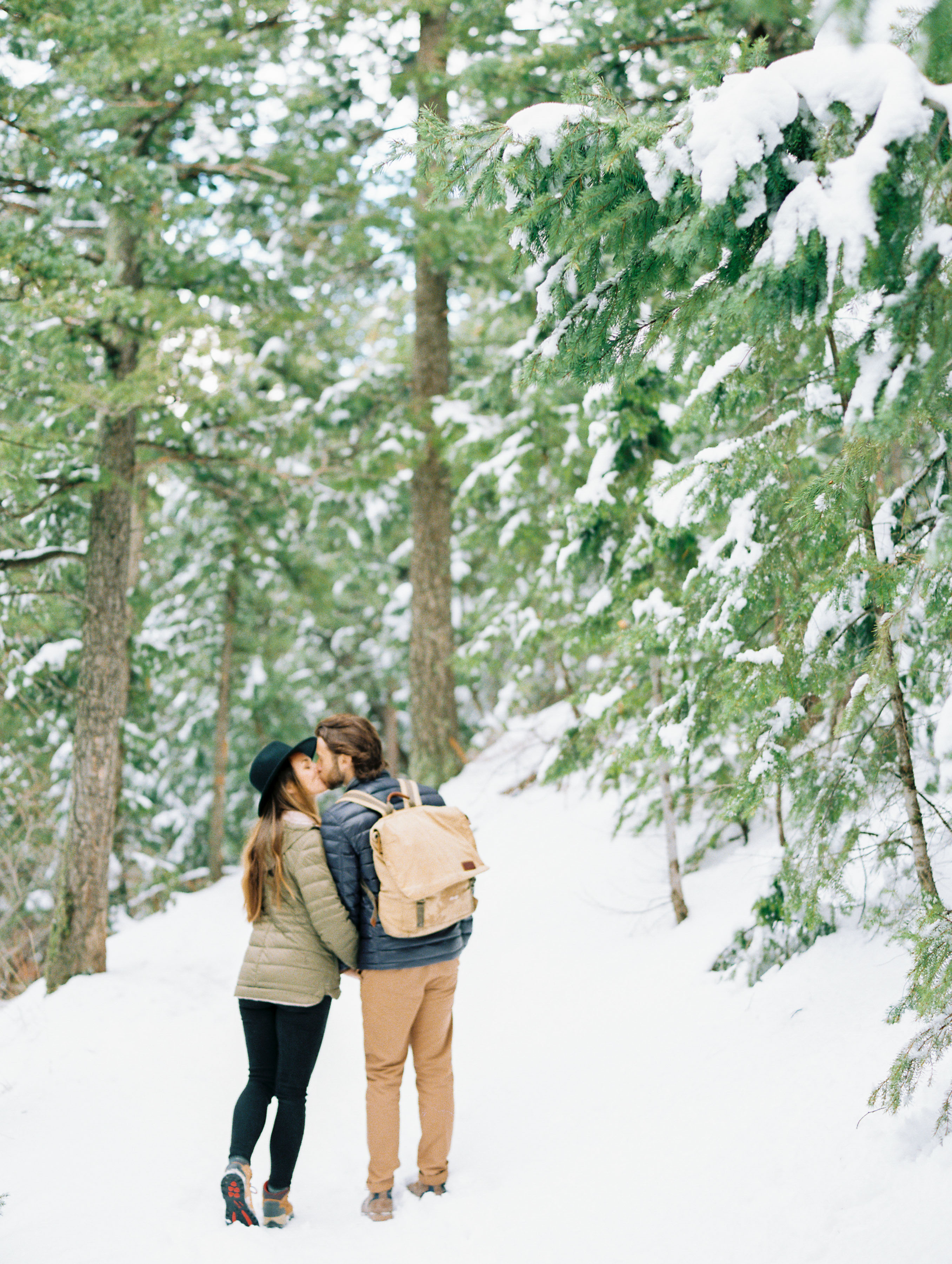 couple kissing in snowy trees
