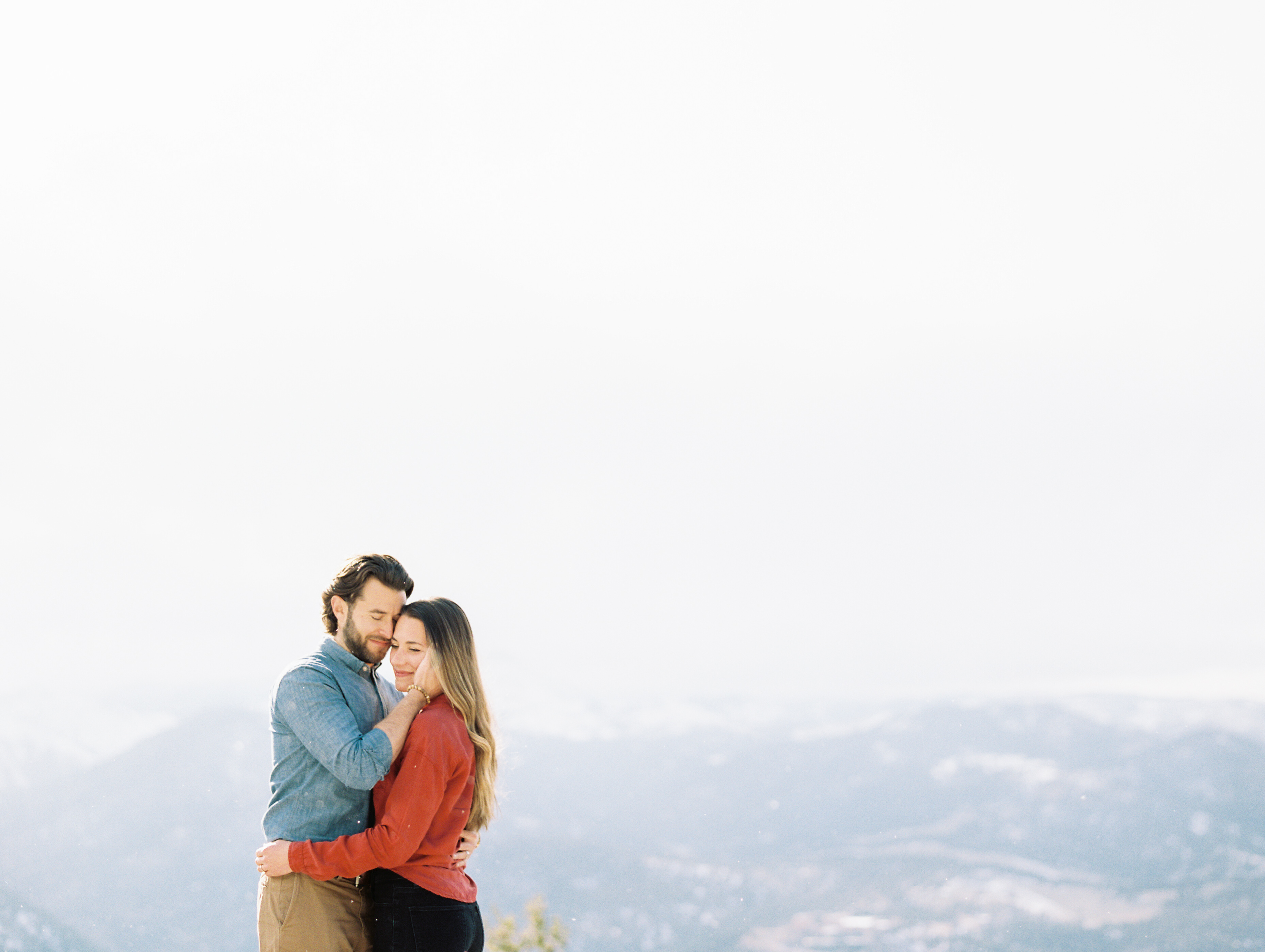 sweet couple nuzzling on mountain overlook