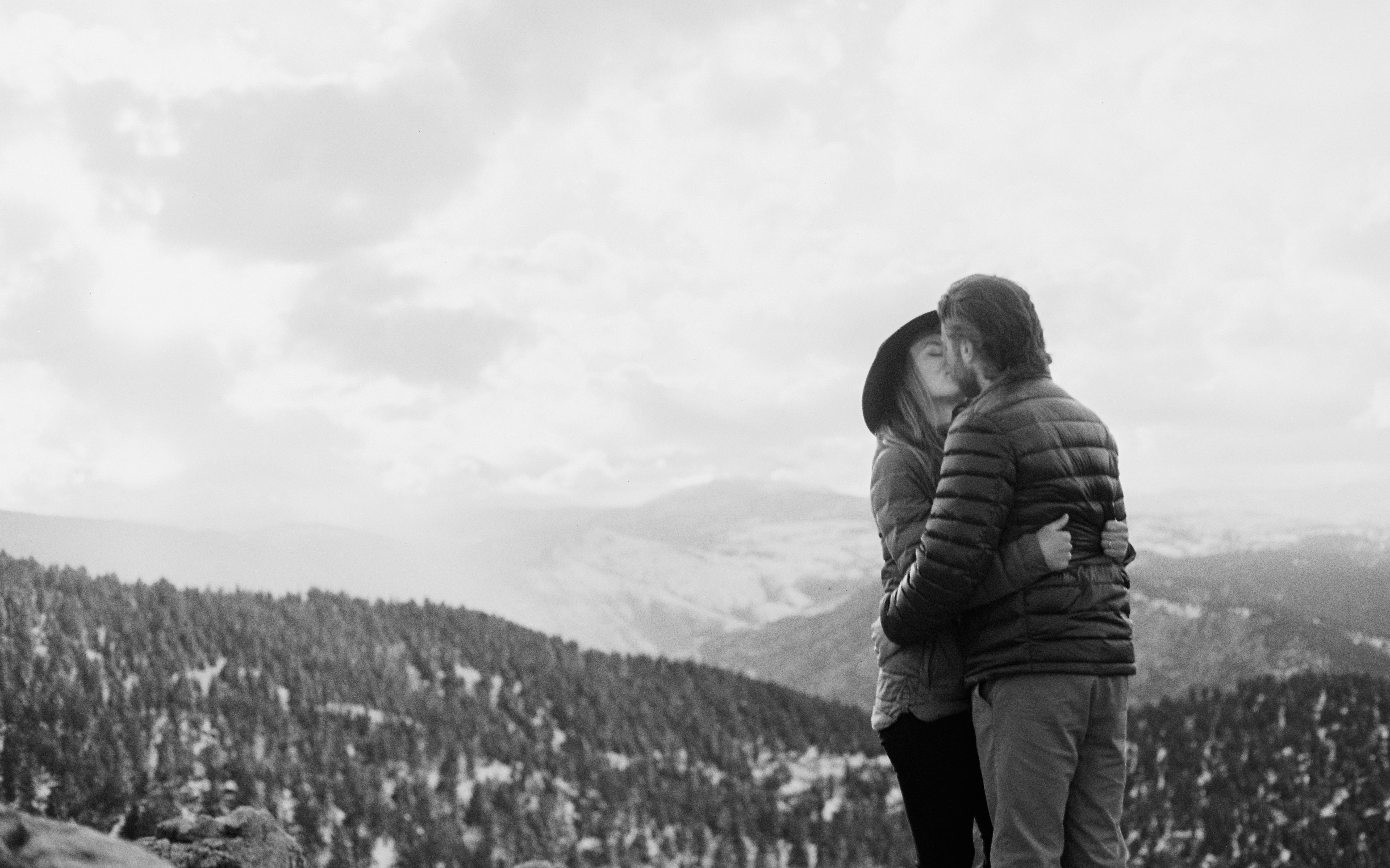 couple kissing looking over mountain range