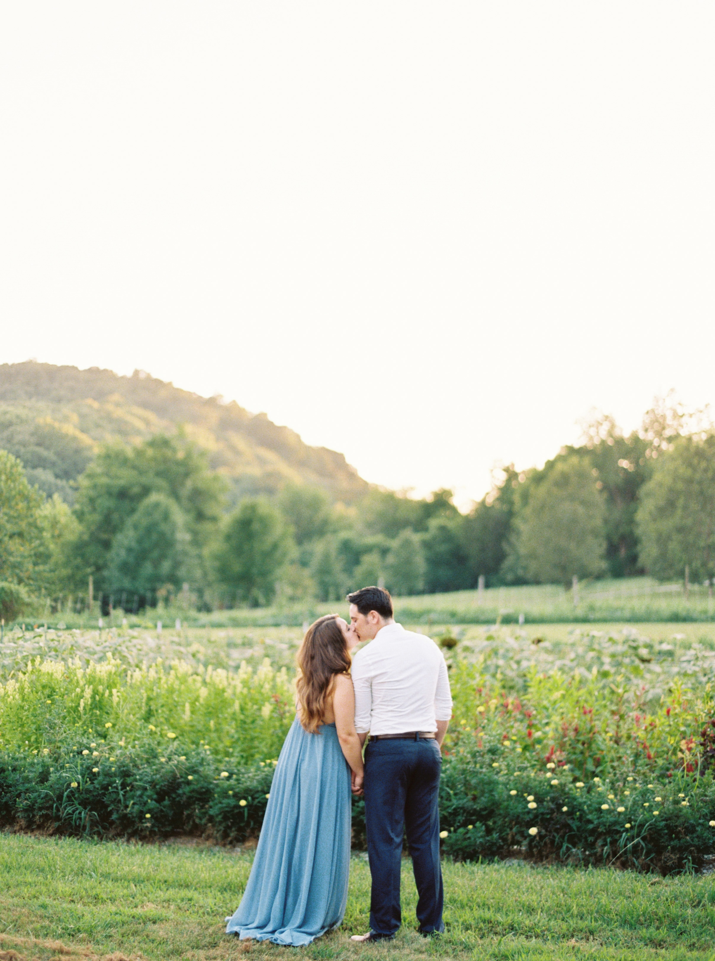 couple kissing with garden in background