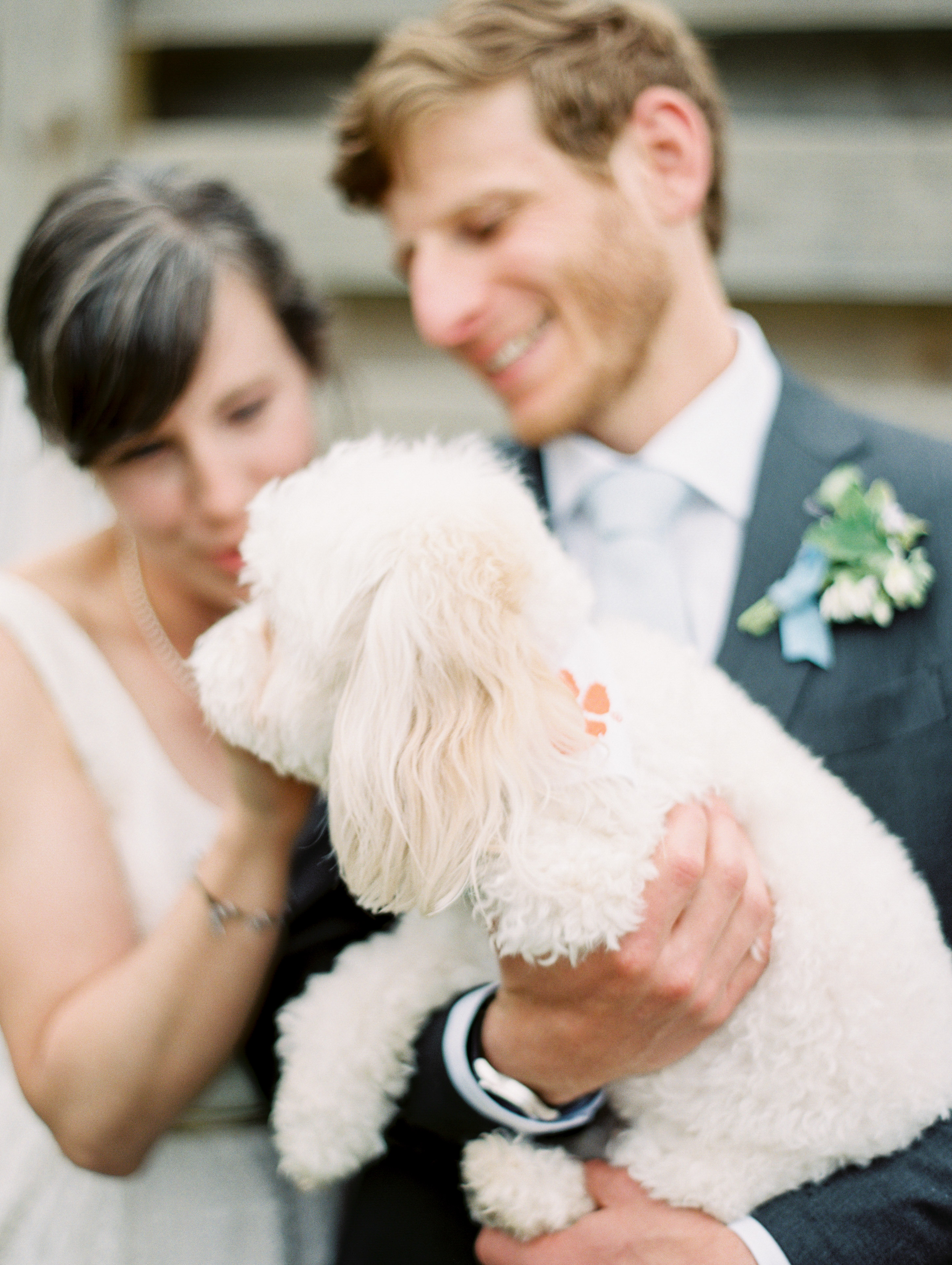 bride and groom cuddling with pup