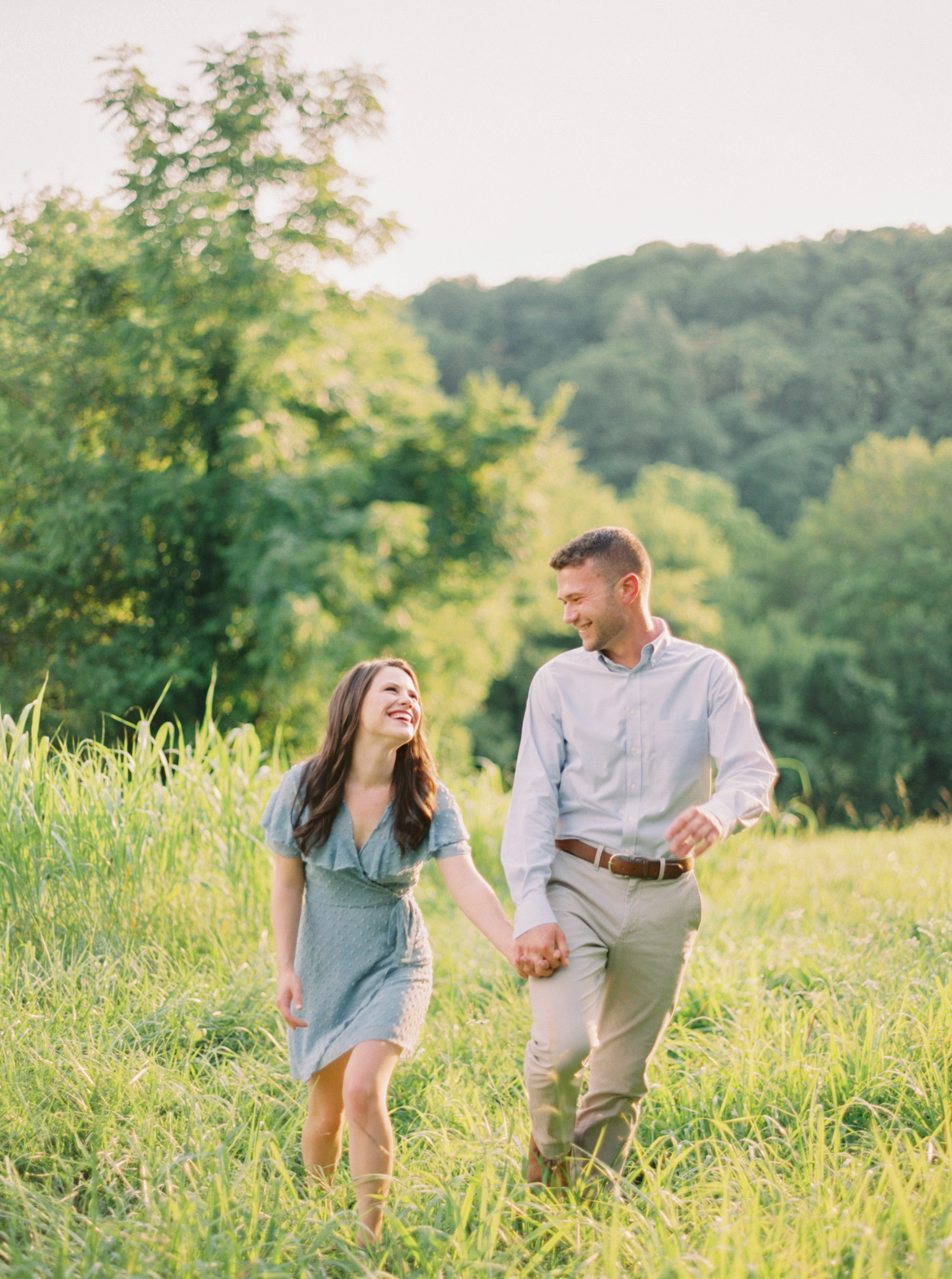 couple laughing while walking through the field