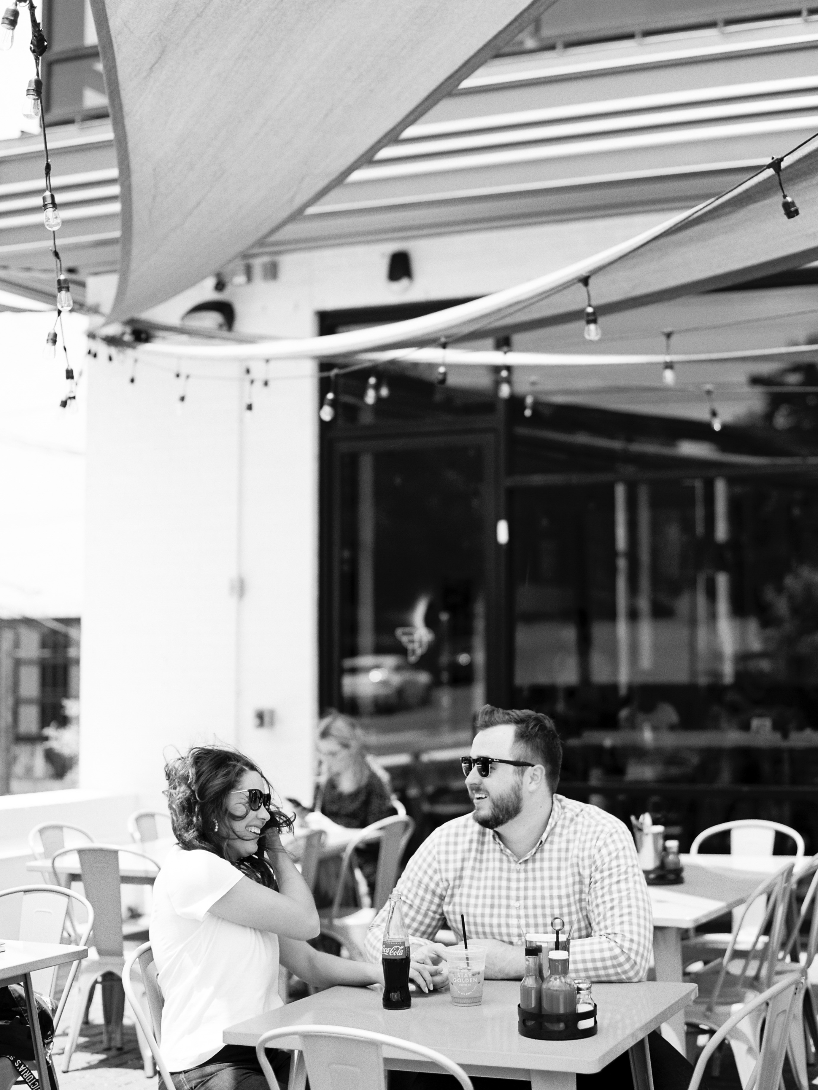 black and white photo of couple laughing having coffee